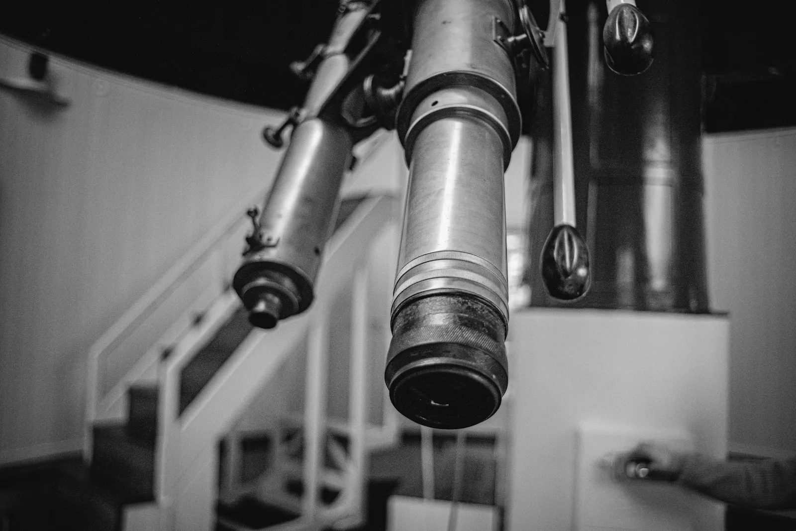 Close-up of a vintage observatory telescope, photographed in black and white.