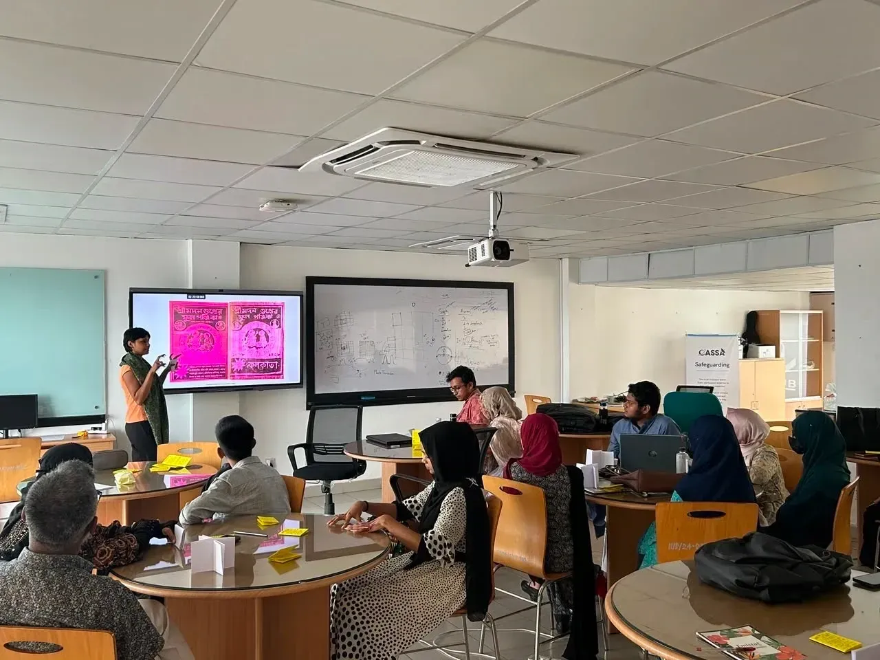 An instructor leading the Drawing to Digital session in front of a screen showing zine artwork.