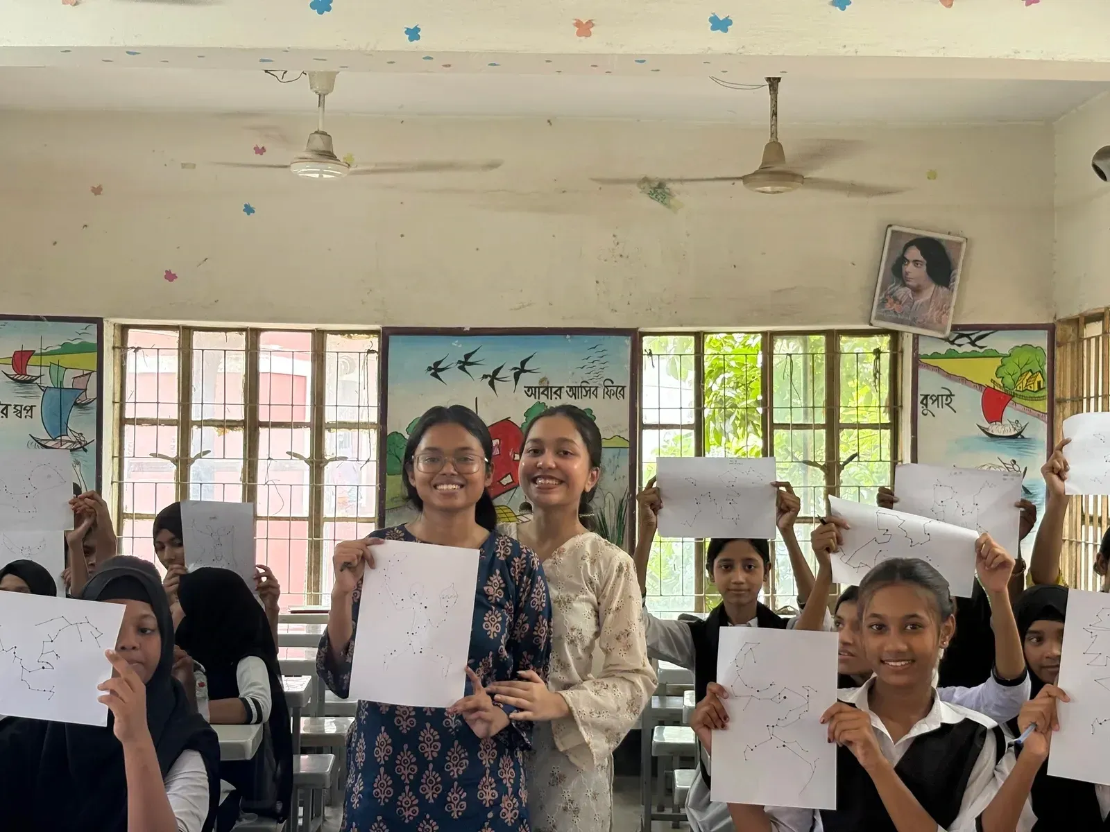 Students proudly holding up their hand-drawn constellation patterns during the Durbin workshop at Moneshwar Government Primary School.