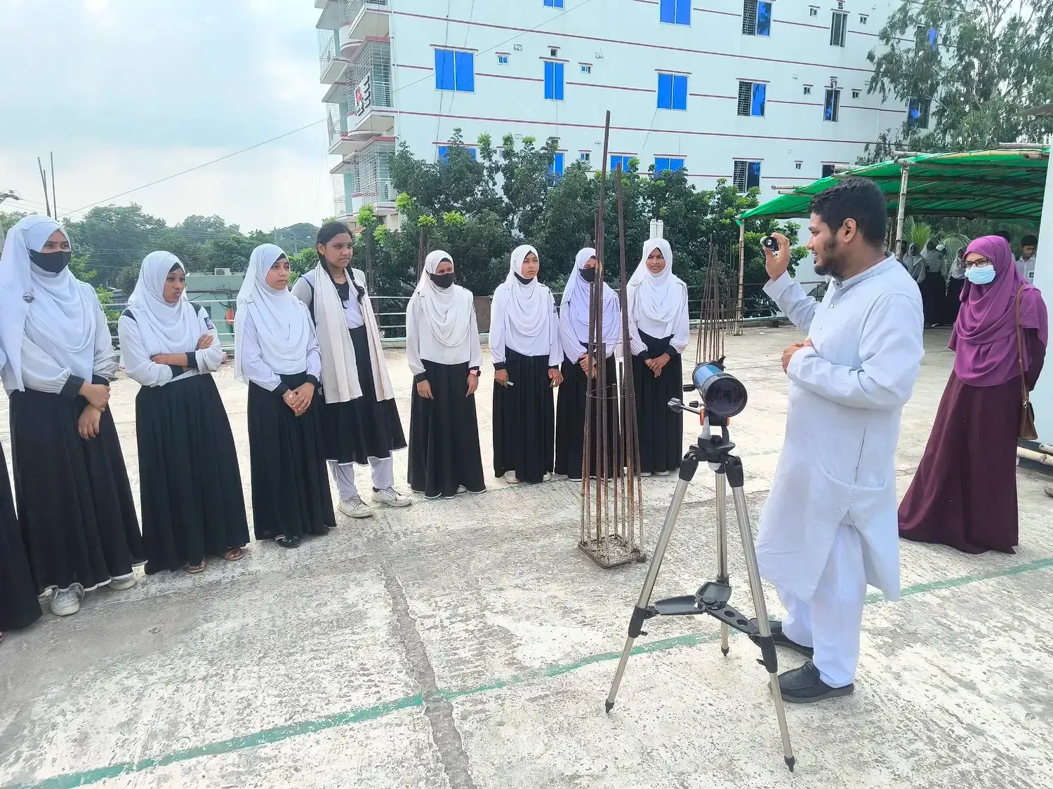 Students learning to use a telescope during Durbin school outreach in Pabna